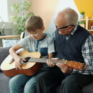 grand-père et enfant qui jouent de la guitare