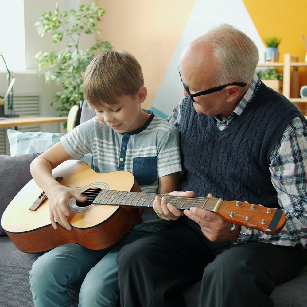 grand-père et enfant qui jouent de la guitare